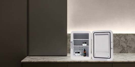 An image of a beauty fridge propped onto a bathroom bench and filled with skincare products.