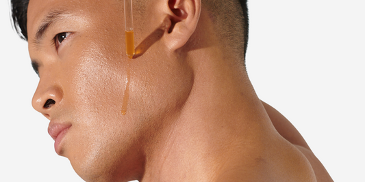 Close up image of a male applying skincare to his face.