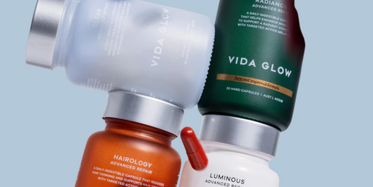 Close up editorial image of supplement bottles aesthetically stacked on top of one another.