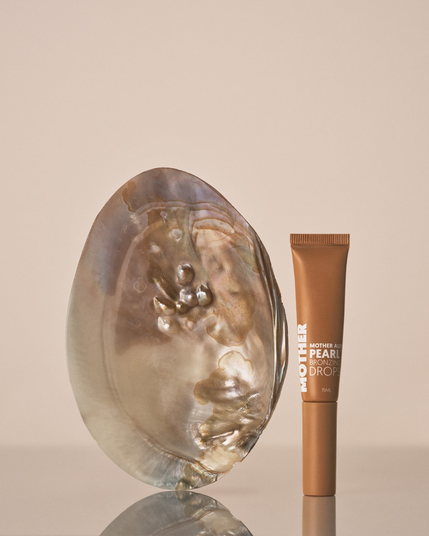 Cosmetic product with pearl-like texture on a beige background