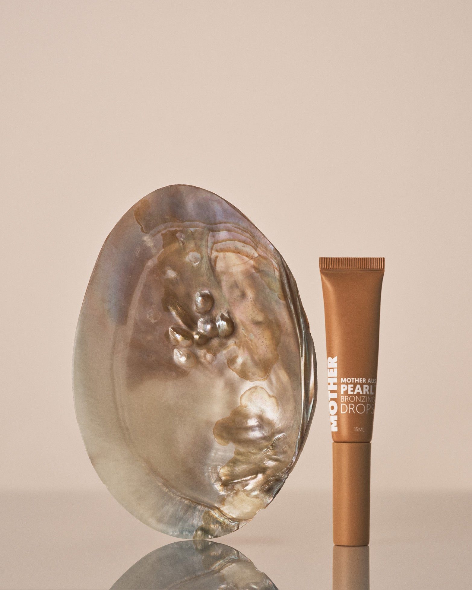 Cosmetic product with pearl-like texture on a beige background